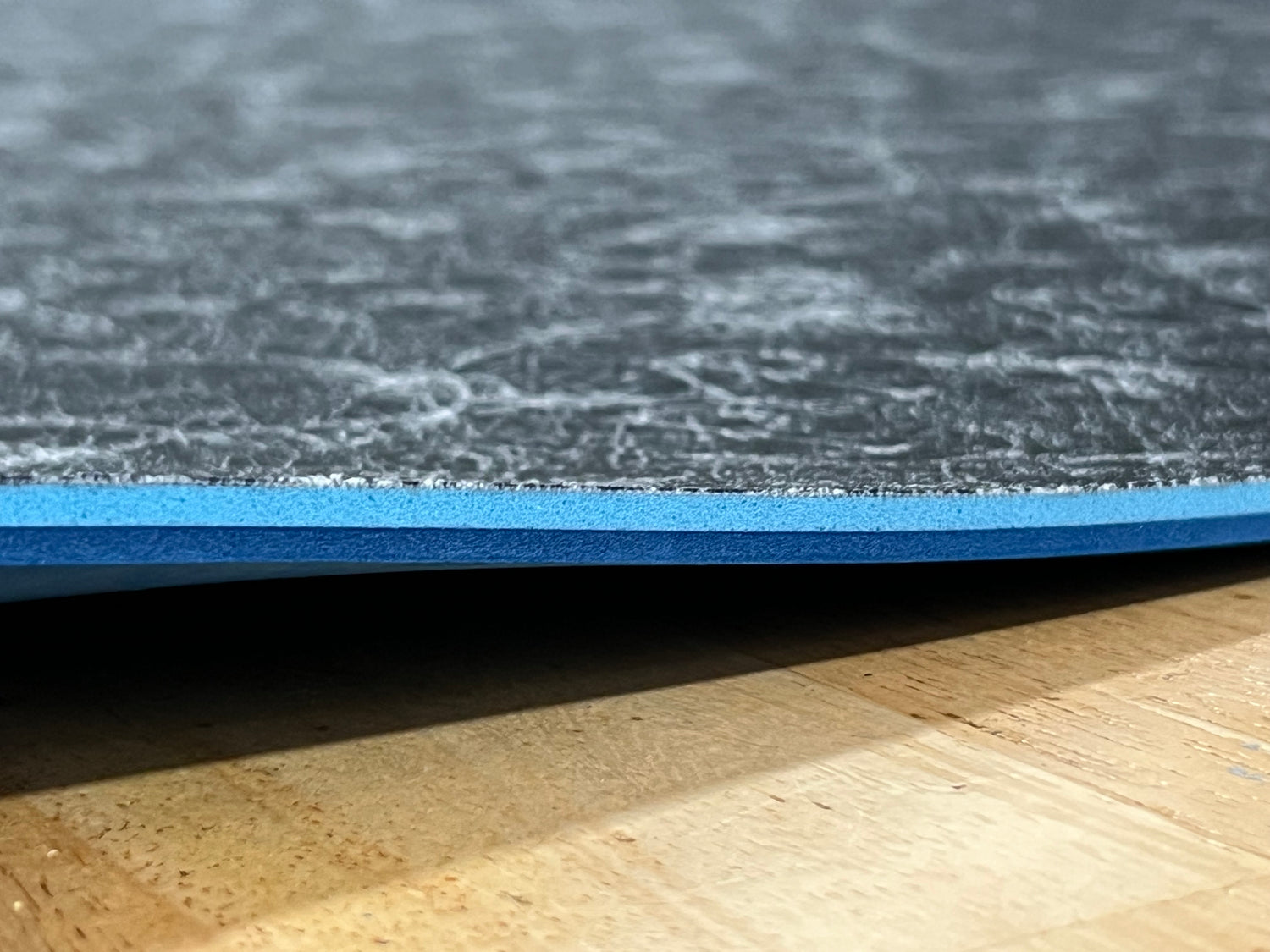 Close-up of textured edge of our 1/4" insole sheet which combines 2 different insole materials plus the Pure silver infused AG 2.0 topliner.
The composition is 1/8"  BounceBlu foam on top, then the 1/8" Plush EVA foam at the bottom.