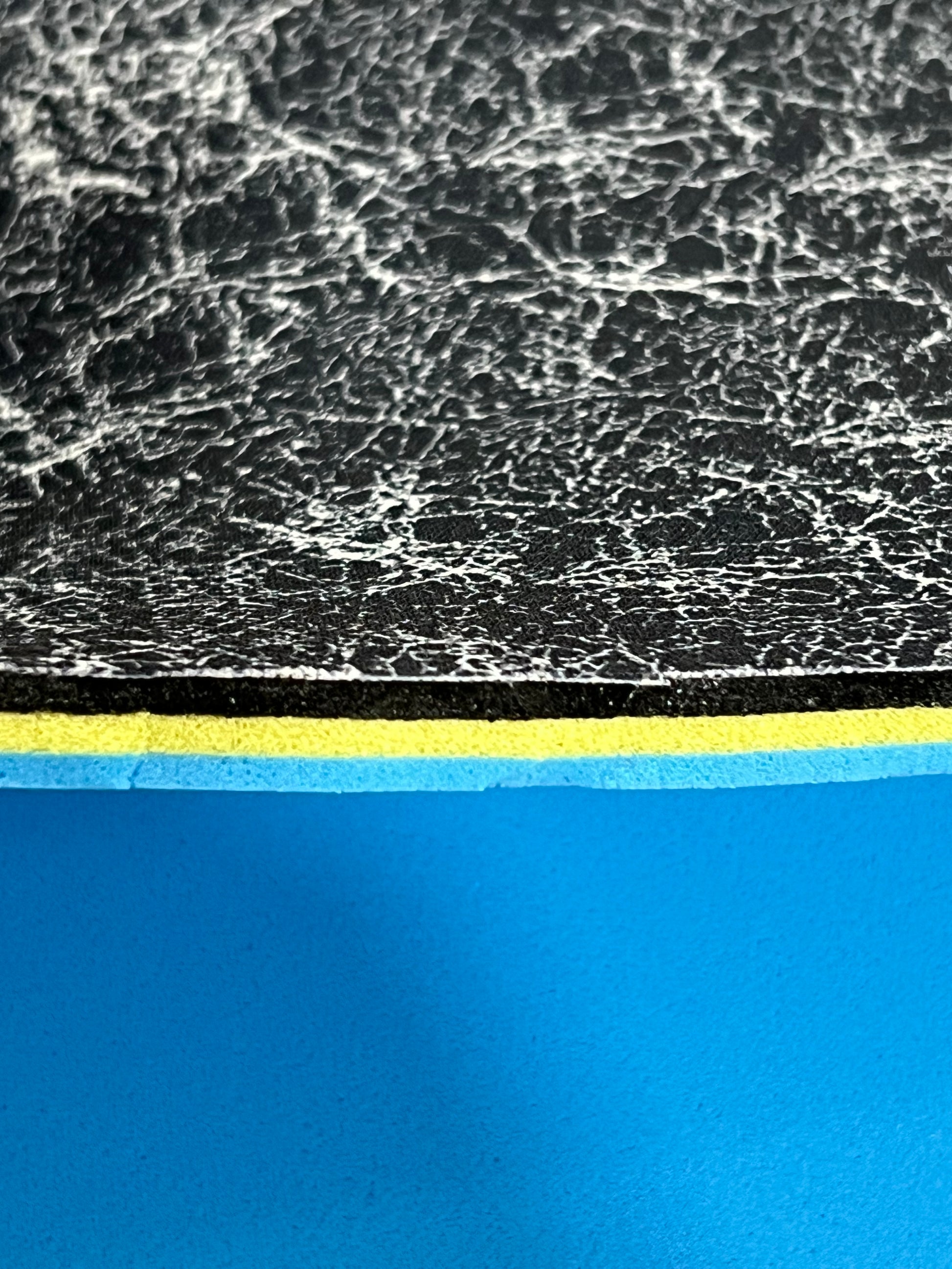 Close-up of textured edge of our 3/8" insole sheet which combines 3 different insole materials plus the Pure silver infused AG 2.0 topliner.
The composition is 1/8" Black Foam Fusion foam on top, then the 1/8" VeloShox foam in the middle with the 1.8" BounceBlu foam at the bottom.