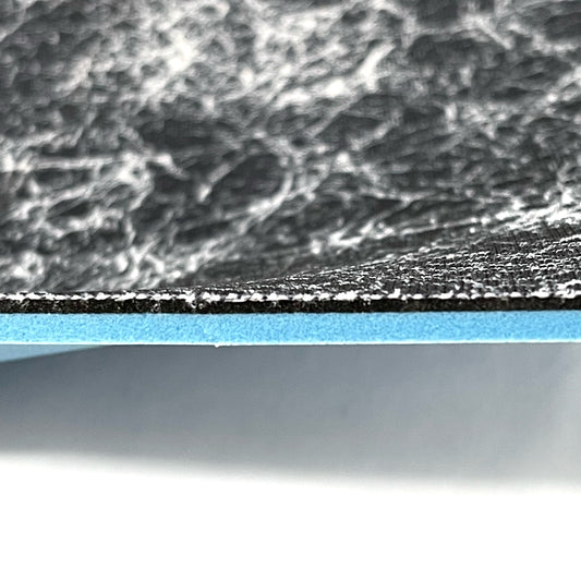 Side profile of insole sheet combination. You can see the silver infused black with silver pattern footbed on top and underneath that a thin 1/16" Black layer of FoamFuzion, then a 1/8" Blue layer of bounceBlue on a white background.